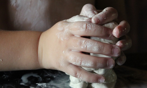 A child's hands moulding clay.